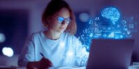 A woman in glasses works on a laptop, with a brain icon displayed on the screen, symbolizing focus or creativity. Best AI Tools for Students